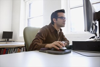Hispanic businessman looking at computer
