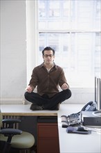 Hispanic businessman meditating