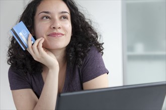 Hispanic woman shopping online with credit card