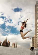 Woman in sportswear jumping on roof