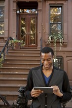 Smiling Black man using digital tablet