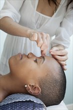 Black woman receiving acupuncture treatments