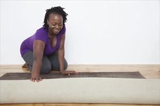 Black woman unrolling carpet