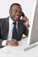 Black businessman talking on telephone at desk