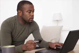 Black man shopping online with credit card