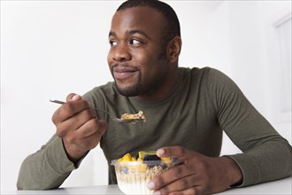 Smiling Black man eating breakfast