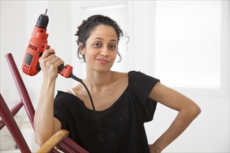 Hispanic woman holding power drill