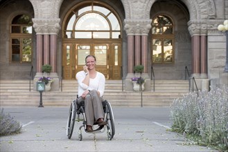 Disabled woman sitting in wheelchair outside courthouse