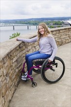 Caucasian disabled girl in wheelchair overlooking Columbus cityscape