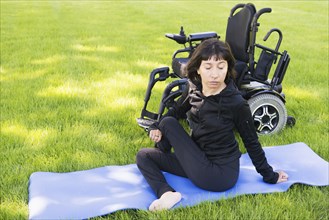 Disabled woman stretching legs in park