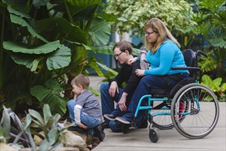Paraplegic woman and family admiring plants