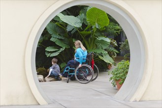 Paraplegic mother and son admiring plants