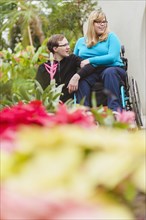 Man and paraplegic girlfriend exploring garden