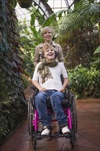 Mother pushing paraplegic daughter in wheelchair