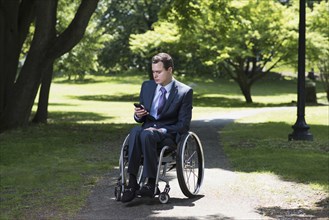 Paraplegic businessman in wheelchair in park