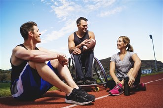 Paraplegic athlete in wheelchair and friends on track