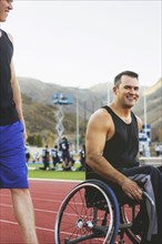 Paraplegic athlete in wheelchair and friend on track