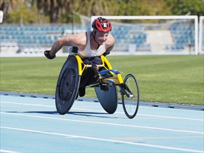 Man racing in wheelchair on track