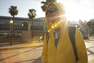 Mixed race woman in hoody and sunglasses walking