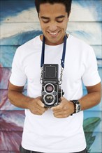 Mixed race man holding old-fashioned camera