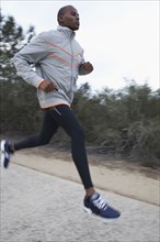 Black man running on road