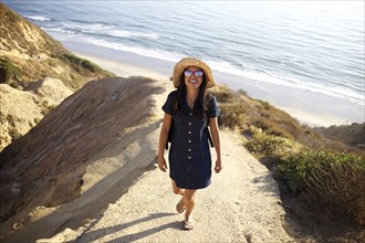 Mixed race woman standing on rock at beach