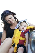Caucasian mother looking at daughter wearing life jacket