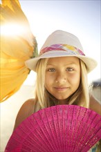 Mixed race girl with large flower and fan