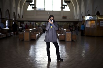 Mixed race woman taking photographs in historic building
