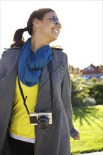 Smiling mixed race woman with old-fashioned camera