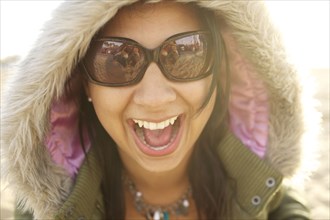 Laughing mixed race woman in fur hood