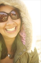 Smiling mixed race woman in fur hood