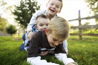 Caucasian brothers playing in grass