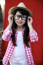 Mixed race girl in hat adjusting eyeglasses