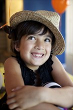 Mixed race girl wearing straw  hat