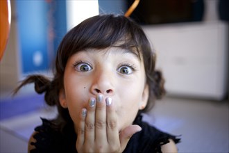 Mixed race girl with hand over mouth