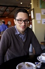 Man smiling at table in cafe