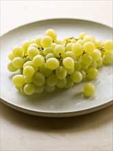 Bunch of green grapes on plate