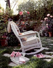 Rocking chair and drinks in blooming garden