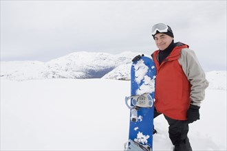 Senior Hispanic man snowboarding