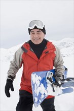 Senior Hispanic man snowboarding