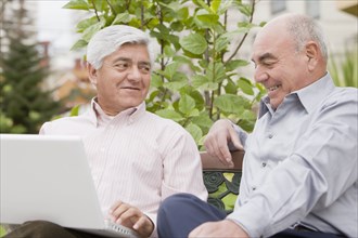 Senior Hispanic friends looking at laptop
