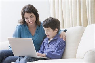 Hispanic mother and son using laptop