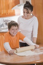Hispanic mother teaching son to bake