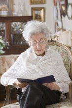 Senior Hispanic woman reading book