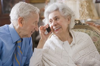 Senior Hispanic couple using cell phone