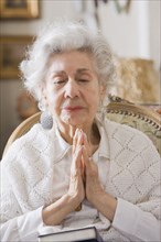 Senior Hispanic woman praying