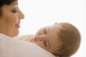 Hispanic mother watching sleeping baby girl