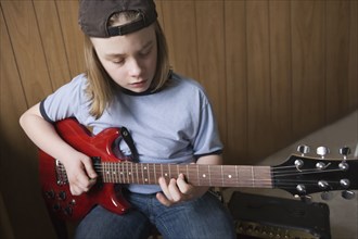 Caucasian boy playing electric guitar