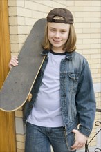 Caucasian boy standing with skateboard